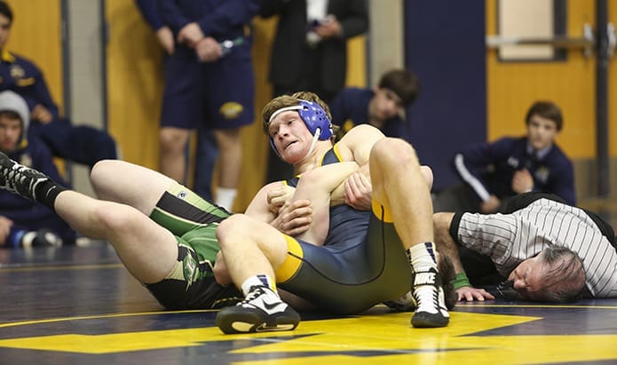 Referee Tom Dursee, right, looks on as Chris Bradley, center, of Marist School, Atlanta, attempts to pin Jonathan Anderson of Blessed Trinity High School, Roswell. Bradley would successfully pin Anderson later in the first period of their 182-pound weight class match. Bradley reached 71 wins and 24 pins with the victory. Photo By Michael Alexander