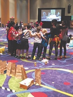 Participants in the “Adore!” track at the Eucharistic Congress take a break during the lively activities at the track to sing together. About 400 children took part in the fun, which included crafts and learning about discipleship. Photo By Katie Buckis