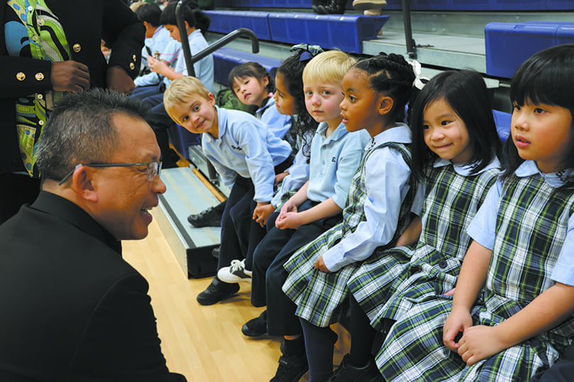 Bishop John N. Tran talks to St. John the Evangelist School students before the Jan. 19 MLK Youth Celebration program, asking them about their planned performance.
