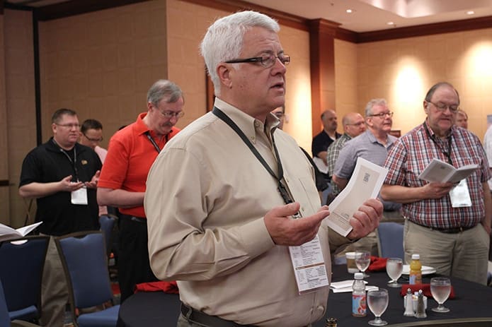 Father Ken Knippel, foreground center, stands with his brother priests during morning prayer at the National Federation of Priestsâ Councils (NFPC) annual convocation, April 30, in Atlanta. Father Knippel is the pastor of St. John the Vianney Church in Brookfield, Wis. Photo By Michael Alexander