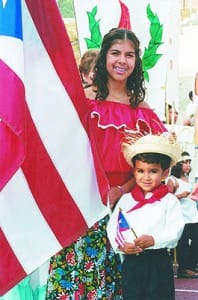 Angela Rodriguez, 13, and her brother Javier Rivera, 4, line up for the procession to kick off the eucharistic celebration marking the canonization of St. Juan Diego at St. Pius X High School, Atlanta, July 31, 2002. Photo By Michael Alexander